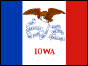 Image of the Iowa State Flag.  The Iowa flag resembles the flag of France, having three vertical blue, white and red stripes, because Iowa was originally part of the territory known as the Louisiana purchase. As well as a reference to the colors of the United States, the color blue stands for loyalty, justice and truth; the white stands for purity; and the red for courage. On the white center stripe is a bald eagle, signifying American liberty and carrying a blue streamer in its beak. The state motto 'Our Liberties We Prize, and Our Rights We will Maintain' is written on the streamer. The name of the state is emblazoned in red letters below the eagle. The flag was adopted in 1921.