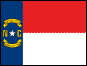 Image of the North Carolina State Flag.  The flag has a blue field with two bars making up the fly; the top one red and the bottom bar white. Centered on the blue field is a white five pointed star. The gilt letters 'N' and 'C' are placed on either side of the white star, with gilt scrolls in semi-circular form, incorporating black lettering, placed above and below the star. The upper scroll displays the date May 20, 1775 representing the date a group of citizens prepared the Mecklenburg Declaration of Independence, which stated that English
laws were no longer in effect in Mecklenburg County. The lower scroll displays April 12, 1776, the date of the Halifax Resolves, authorizing the state's delegates at the Continental Congress to sign the Declaration of Independence. The flag was adopted in 1885.