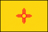 Image of the New Mexico State Flag.  The flag's simple and meaningful design features an interpretation of an ancient symbol of the sun as found on a late 19th century water jar from Zia Pueblo. This red symbol is called a 'Zia' and is centered on a field of yellow. The red and yellow colors are the colors of Isabel of Castilla brought to the continent by the Spanish Conquistadors. On the flag can be seen a red sun with rays streching out from it. There are four groups of rays with four rays in each group. This is an ancient sun symbol of a Native American people called the Zia. The Zia believed that the giver of all good gave them gifts in groups of four. Four is the sacred number of the Zia and can be found repeated in the four points radiating from the circle. The number four is embodied in the four points of the of the compass, North, East, South and West; in the four seasons of the year Spring, Summer, Autumn and Winter; in the 24 hours of each day by sunrise, noon, evening and night; and by the four seasons of life itself, childhood, youth, adulthood and old age. The Zia also believed that with life came four sacred obligations: development of a strong body, a clear mind, a pure spirit and devotion to the welfare of people/family. All of these things are bound together within the circle of life and love, without a beginning or end. The flag was adopted in 1925.